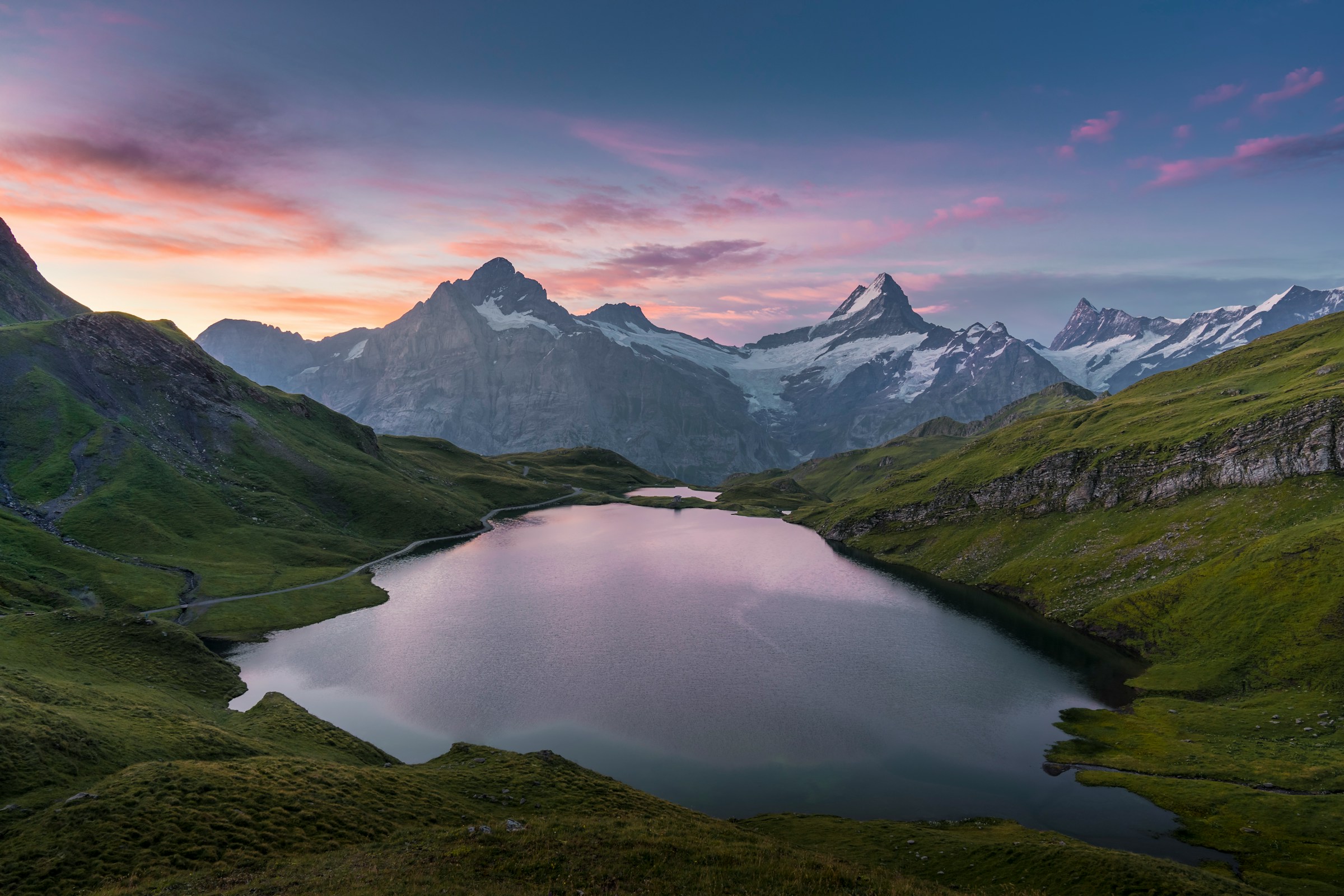Alpine mountain lake at sunset with snow-capped peaks